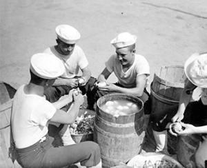 These WWI-era Sailors help out by peeling thousands pf potatoes.